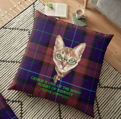 a cat wearing glasses on top of a plaid floor pillow