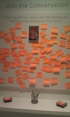 orange sticky notes are on the wall next to a vase