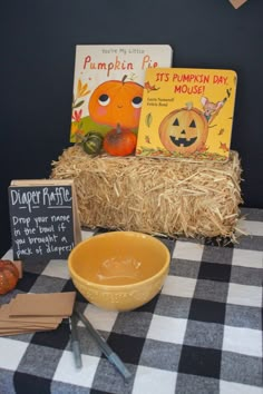 a table with books, pumpkins and a bowl of soup on top of it