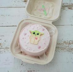 a baby yoda cake in a plastic container