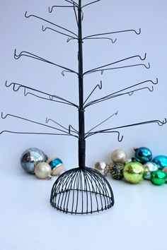 a wire christmas tree with ornaments around it