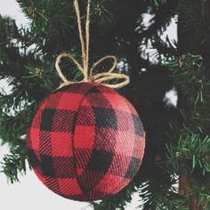 an ornament hanging from a christmas tree in the shape of a red and black plaid ball