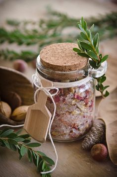 a jar filled with lots of food sitting on top of a wooden table next to nuts