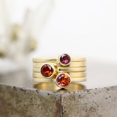 "This 14k yellow gold gemstone stack ring set features five rings - three have gems set in yellow gold bezels: mystic topaz, madeira citrine and grape garnet. Two more rings are included for stacking. Wear them stacked up on the same finger, or separately! Each ring in the stacking set is a size 7 but because wide stacks fit differently than thinner, single rings, this will fit down to a 6.5 comfortably. Ring bands:  Three 1mm thick x 1.5mm wide with gemstones, lightly polished finish Two 1mm th Modern Gold Multi-stone Gemstones, Modern Gold Multi-stone Sapphire Ring, Modern Gold Sapphire Ring With Multi-stone, Gold Round Stackable Gemstones, Gold Fusion Rings With Gemstone Accents, Modern Gold Gemstone Birthstone Ring, Modern Gold Birthstone Ring With Gemstone, Gold Stackable Gemstones Fine Jewelry, Gold Stackable Gemstones For Fine Jewelry