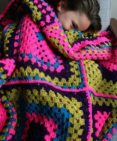 a child wrapped up in a crocheted blanket