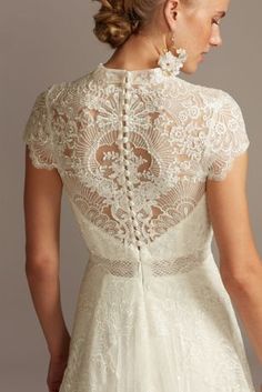 a woman wearing a wedding dress with an open back and lace detailing on the top