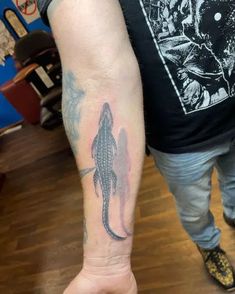 a man's arm with a lizard tattoo on it