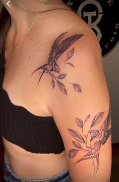 a woman with a bird and flower tattoo on her shoulder