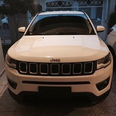 a white jeep parked in front of a house