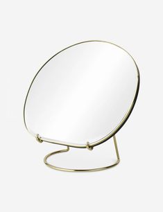 a round mirror sitting on top of a metal stand