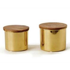 two small gold canisters with wooden lids