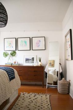 a bed room with a neatly made bed and pictures on the wall