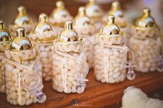 small glass jars filled with white candies on top of a wooden table next to other items