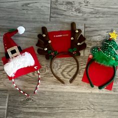 three christmas themed headbands are laying on the floor next to each other and one is wearing a santa hat