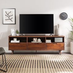 a flat screen tv sitting on top of a wooden entertainment center in a living room