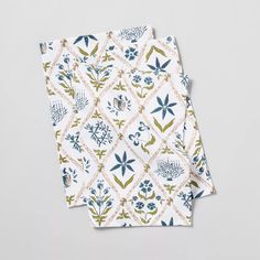 two napkins with blue and green floral designs on them, one is folded to the side