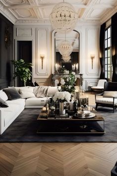 a living room filled with lots of white furniture and black walls, along with a chandelier