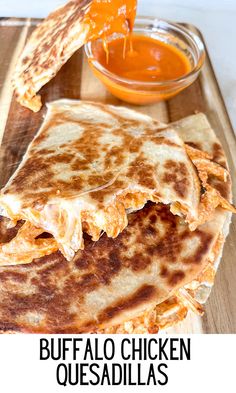 a quesadilla cut in half on a cutting board with the words buffalo chicken quesadillas