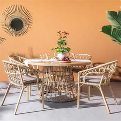 a round table with four chairs around it and a potted plant in the middle