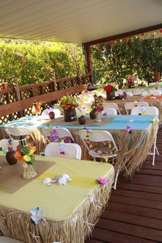 an outdoor dining area with tables and chairs set up for a party or gathering on the deck