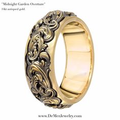 a wedding ring with an intricate design on the outside and gold in the inside, against a white background