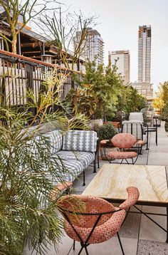 an outdoor seating area with chairs, tables and potted plants on the roof terrace