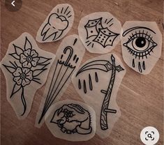 some stickers that are on top of a wooden table and one has an eye