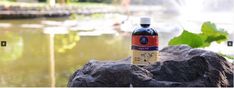 a bottle of water sitting on top of a rock