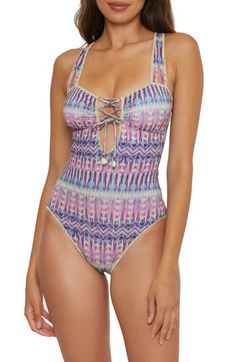 Shimmery threads elevate the bold pattern on this classic one-piece swimsuit designed with a lace-up detail in the front and adjustable tie straps in the back. Ties at back Removable cups 57% polyester, 22% nylon, 13% metallic fibers, 8% spandex Hand wash, line dry Imported Summer Lace-up Back Swimwear For Poolside, Summer One-piece Swimwear With Lace-up Back, One-piece Swimwear With Lace-up Back For Summer, Beachwear Swimwear With Lace-up Back, Beachwear Swimwear With Lace-up Back For Vacation, Lace-up Back Swimwear For Beach Season, One-piece Lace-up Back Swimwear, Becca Swimwear, Spring Wardrobe Essentials