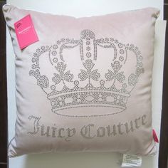 a white pillow with a crown on it and a pink tag attached to the back