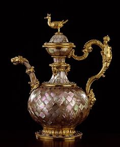 an ornately decorated glass tea pot on a table