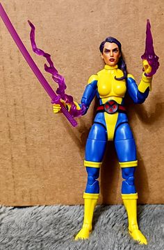 the action figure is holding two purple swords