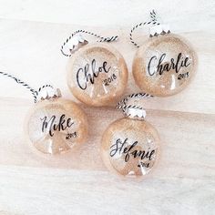 three personalized christmas ornaments hanging from twine