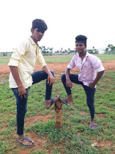 two men standing next to each other in a field