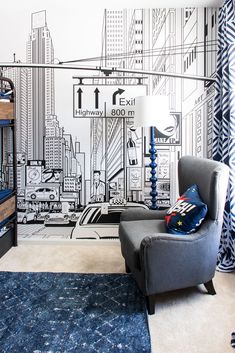 a bedroom with a blue rug and black and white wallpaper on the walls, along with a gray chair