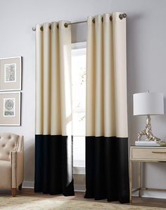 black and white curtains in a living room with a beige chair next to the window