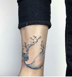 a woman's leg with a tattoo on it that has water splashing out of it