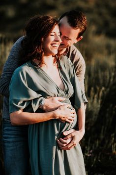 a man and woman hugging each other in an open field