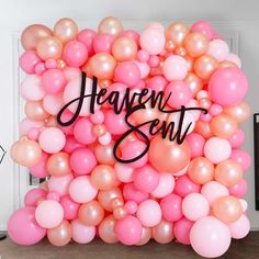 a bunch of balloons with the words heaven sent written on them in black lettering and pink and peach colors