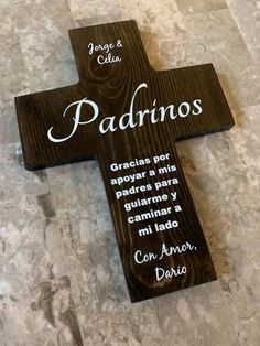 a wooden cross with words on it sitting on the floor in front of a wall