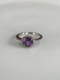 "This lovely halo ring features one round amethyst surrounded by tiny round diamonds that extend to about 1/4\" along the band on either side. The delicate purple shine of the amethyst and the twinkle of the diamonds make this ring simply dreamy! It is marked 14K, is a size 6 1/2 and is in beautiful condition. Please see all photos for details. Thank you for looking! I'm happy to offer layaway on certain items. Please ask for details." Elegant Purple Amethyst Ring With Round Band, Elegant Lavender Amethyst Ring, Classic Purple Diamond Ring With Halo Setting, Classic Purple Diamond Ring With Accent Stones, Classic Purple Amethyst Ring With Round Cut, Classic Purple Amethyst Ring Round Cut, Classic Purple Amethyst Round Cut Ring, Classic Purple Jewelry With Halo Setting, Formal Lavender Rings With Halo Setting