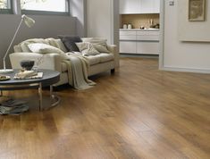 a living room with hard wood floors and white furniture