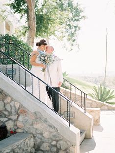 a bride and groom walking down the stairs