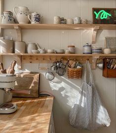 a kitchen with shelves filled with pots, pans and utensils on it