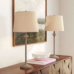 two lamps sitting on top of a table next to a bowl