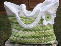 a green and white crocheted bag sitting on top of a table