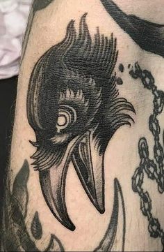 a close up of a person's leg with a bird tattoo on the side