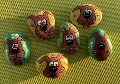 four painted rocks with cartoon dogs on them