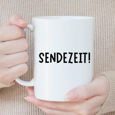 a woman holding a white coffee mug with the word sendezit printed on it