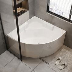 a white bath tub sitting on top of a bathroom floor next to a shower stall